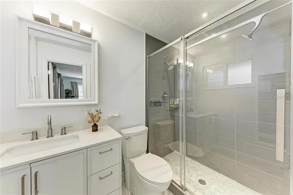 a bathroom with a sink a toilet and shower