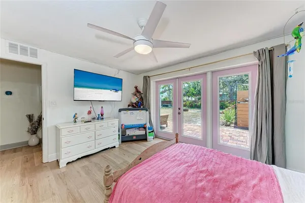 a bedroom with a bed dresser and a large window