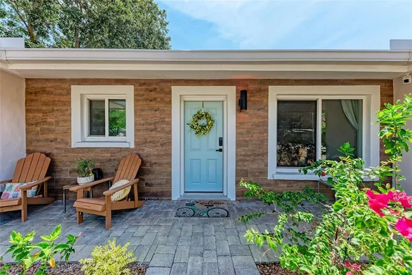 a front view of a house with outdoor seating and potted plants