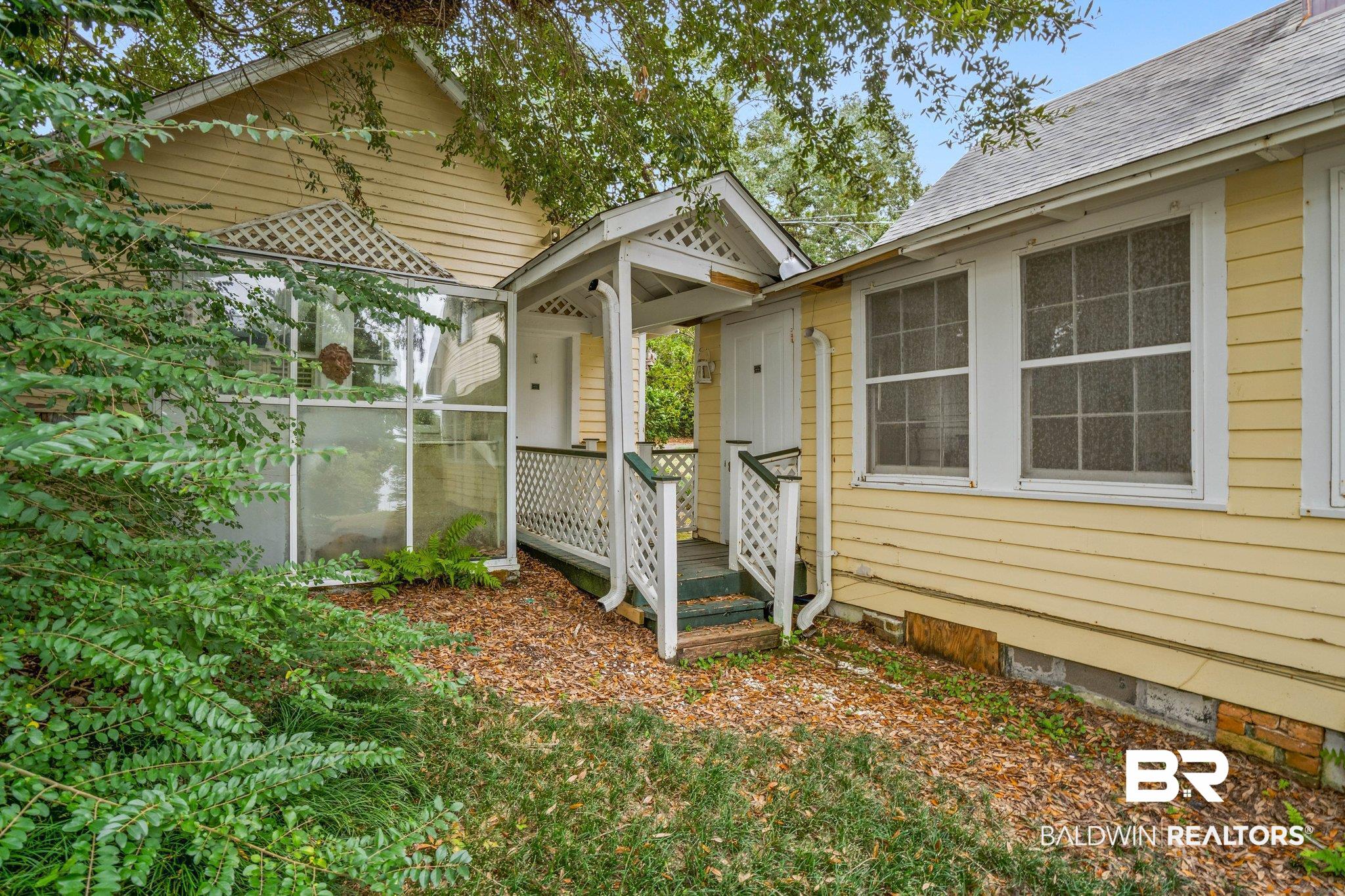 23561 Main Street Fairhope, AL 36532 - Photo 41 of 45 Property entrance featuring crawl space, a shingled roof, and a wooden deck
