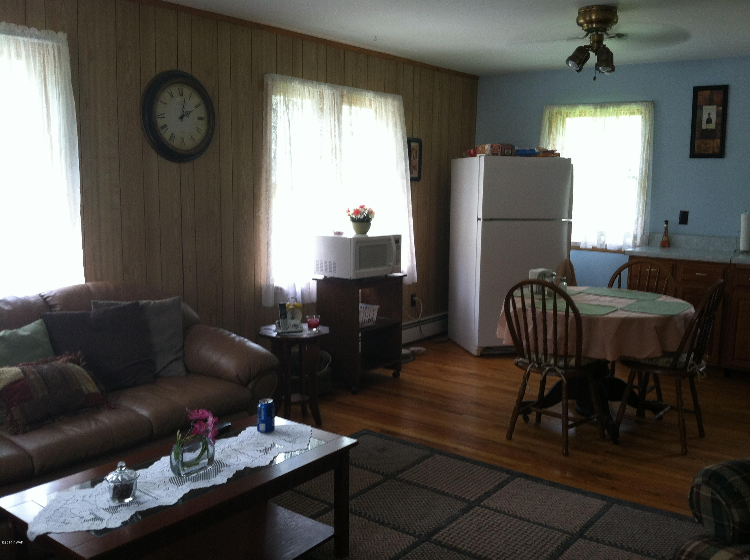 85 Elk Brook Road Road Delhi, NY 13753 - Photo 11 of 11 a living room with furniture a dining table and a refrigerator