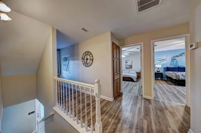 a view of a hallway view with wooden floor and living space