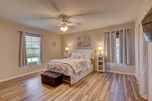 a spacious bedroom with a bed and wooden floor