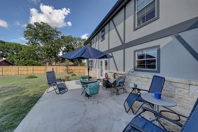a view of a patio with chairs and an umbrella