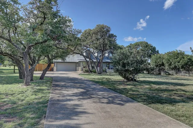 a front view of a house with a yard and an trees