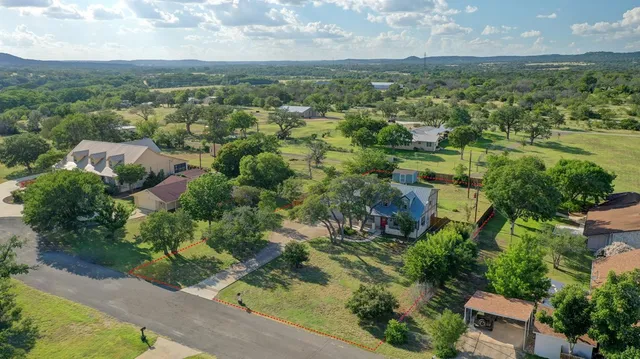an aerial view of residential houses with outdoor space and trees