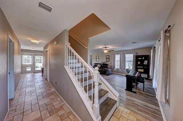 a view of a hallway with wooden floor and staircase