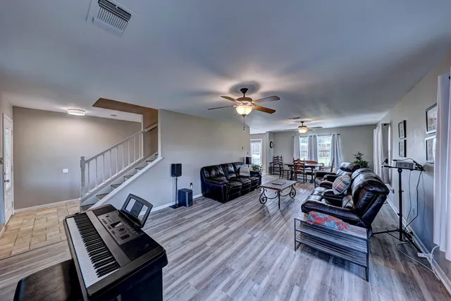 a living room with furniture and a wooden floor