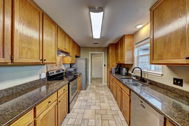 a kitchen with stainless steel appliances a sink stove and cabinets