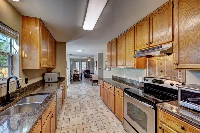 a kitchen with stainless steel appliances a sink a stove and cabinets