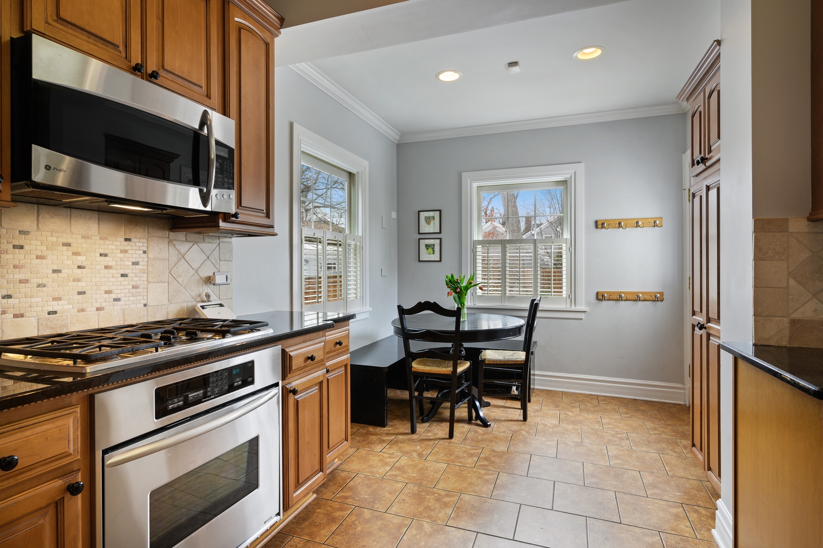1054 Tower Road Winnetka, IL 60093 - Photo 13 of 32 a kitchen with stainless steel appliances a stove a sink and a microwave