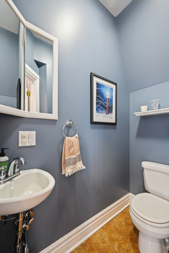 1054 Tower Road Winnetka, IL 60093 - Photo 17 of 32 a bathroom with a toilet a sink and mirror