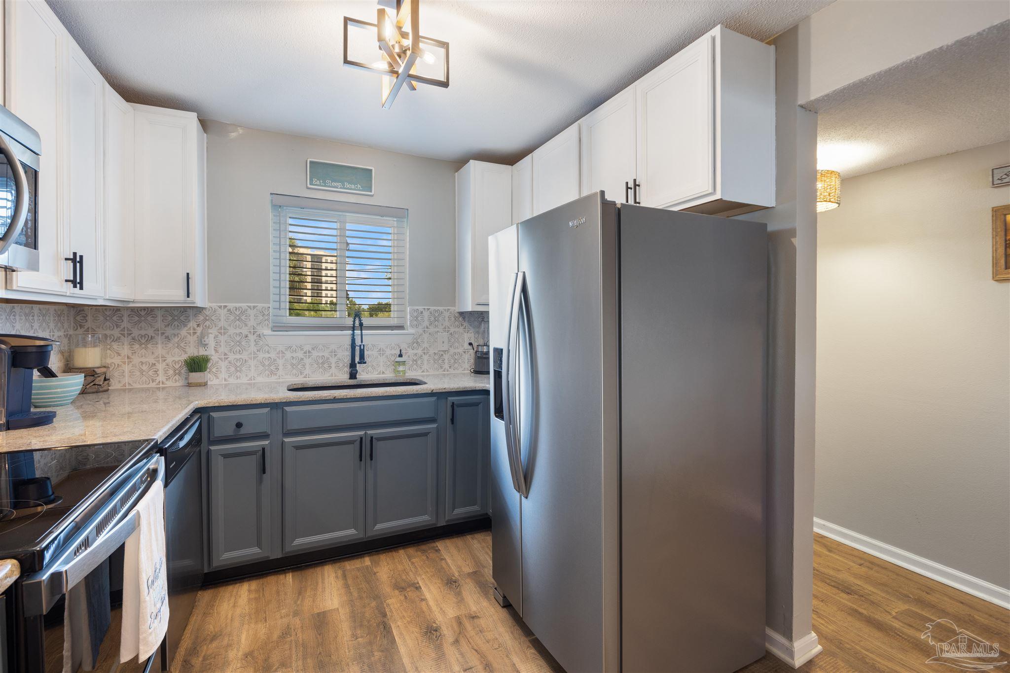 14100 River Road, Unit 122B Perdido Key, FL 32507 - Photo 8 of 46 a kitchen with stainless steel appliances granite countertop a refrigerator and a sink