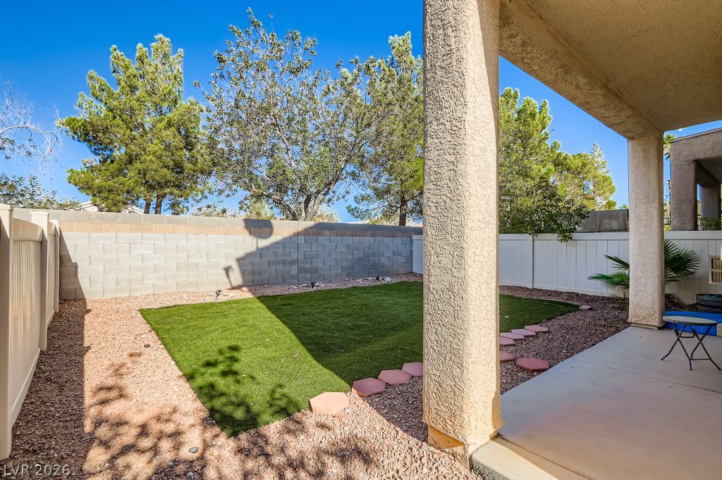 1586 Rusty Ridge Lane Henderson, NV 89002 - Photo 11 of 11 A well-maintained rear yard features a covered patio and artificial turf.