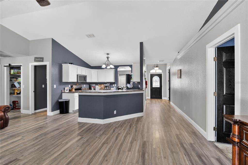 105 Pecan Pass Ocala, FL 34472 - Photo 5 of 25 a large kitchen with stainless steel appliances kitchen island a large counter top and a wooden floors