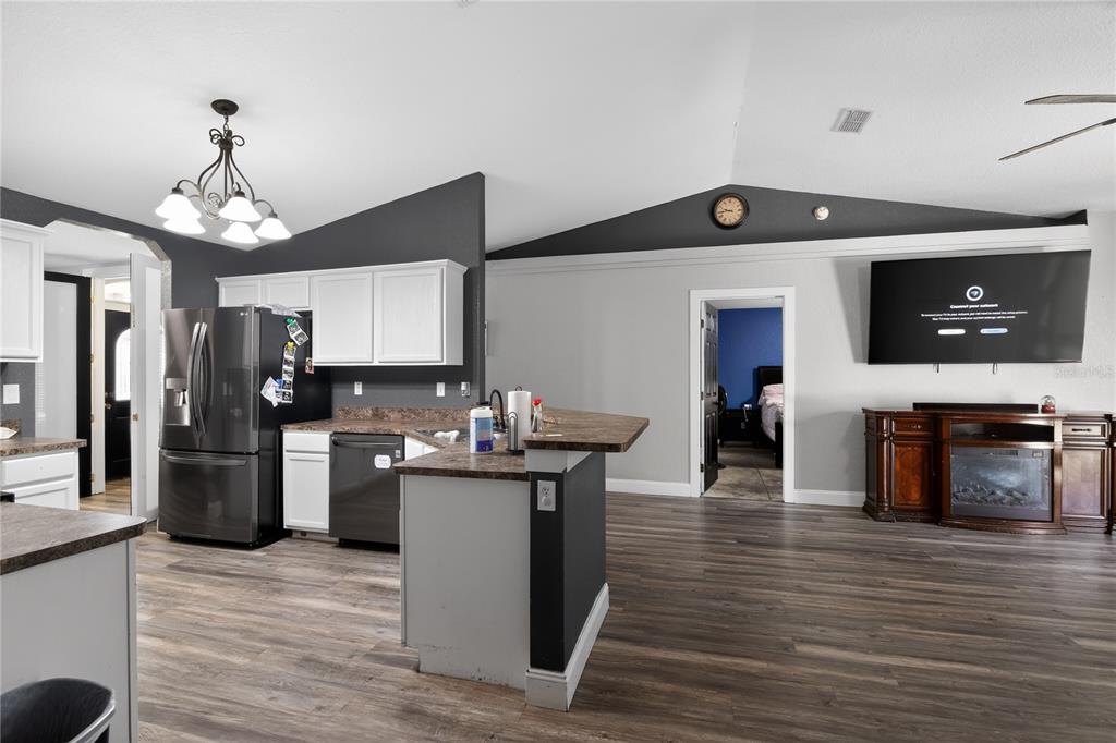 105 Pecan Pass Ocala, FL 34472 - Photo 6 of 25 a kitchen with stainless steel appliances granite countertop a refrigerator a stove top oven a sink dishwasher and white cabinets with wooden floor