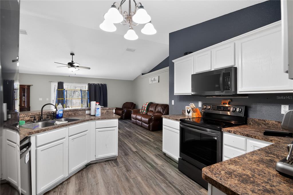 105 Pecan Pass Ocala, FL 34472 - Photo 7 of 25 a kitchen with a stove a sink and a microwave