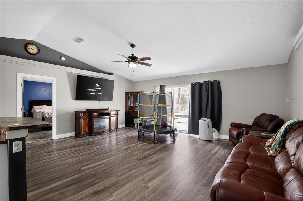 105 Pecan Pass Ocala, FL 34472 - Photo 10 of 25 a living room with furniture and a flat screen tv with kitchen view