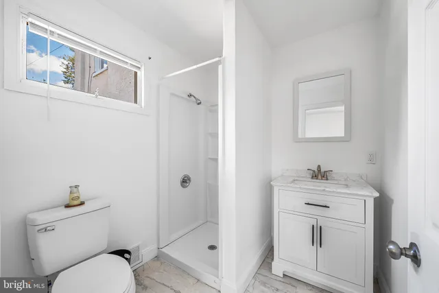 a bathroom with a toilet sink vanity and mirror