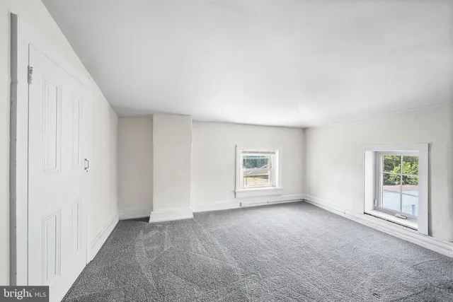 an empty room with windows and closet