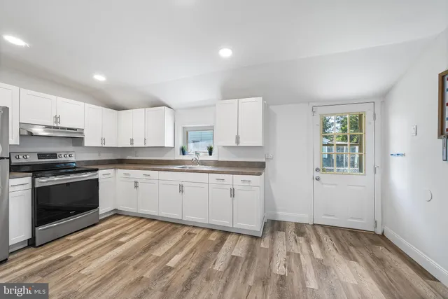 a kitchen with granite countertop white cabinets and appliances
