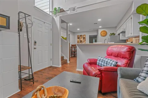 a living room with furniture and a wooden floor
