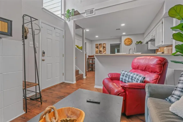 a living room with furniture and a wooden floor