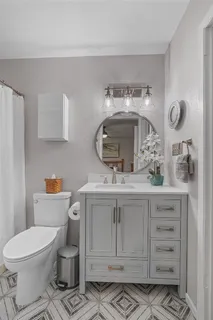 a bathroom with a toilet sink and mirror