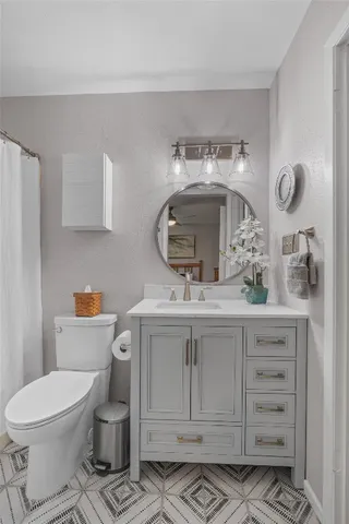 a bathroom with a toilet sink and mirror
