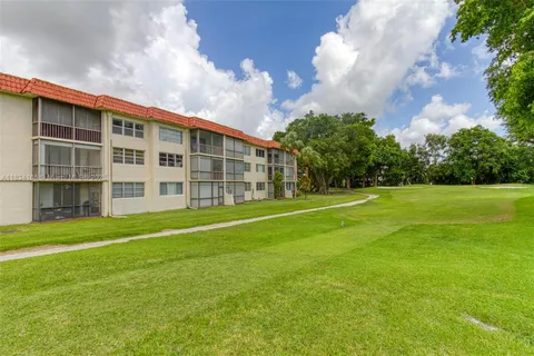 a view of a house with a big yard and large trees