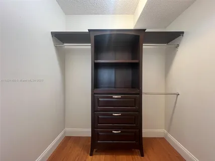 a room with walk in closet and wooden floor