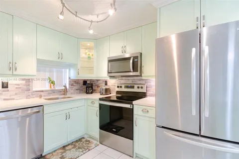 a kitchen with a sink stainless steel appliances and white cabinets