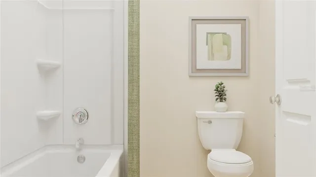 a white toilet sitting next to a bathroom sink
