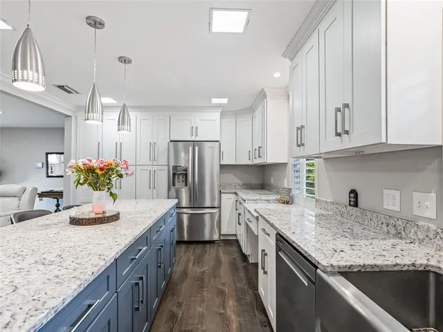 a kitchen with kitchen island granite countertop a sink stainless steel appliances and cabinets