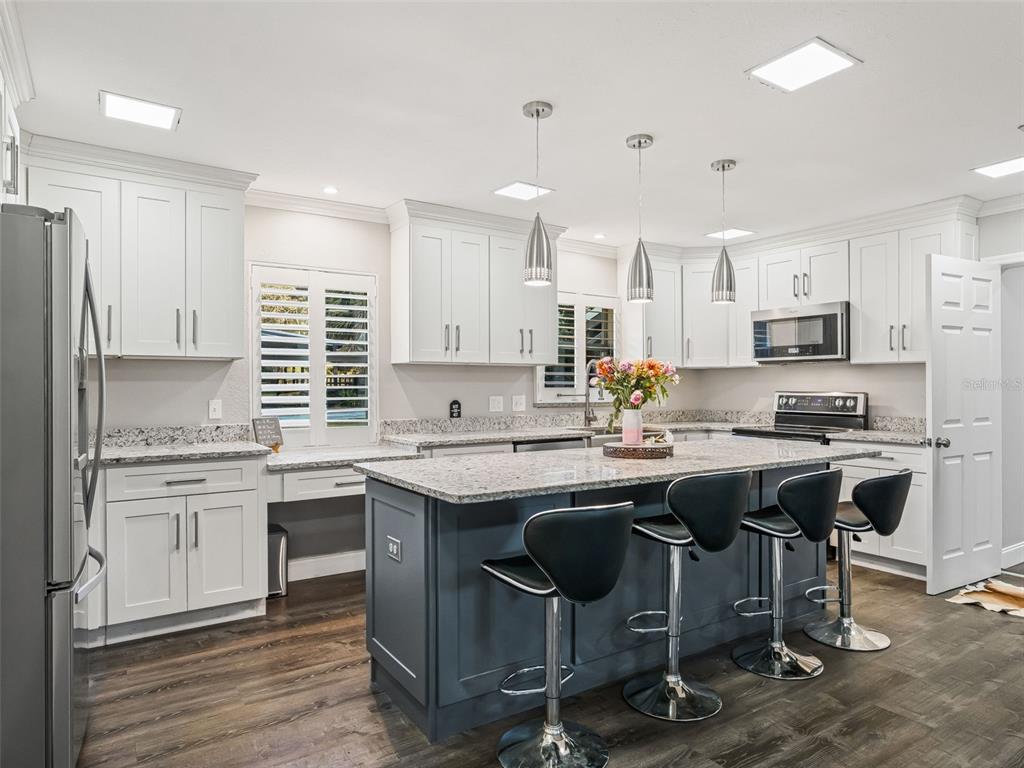 3505 Northeast 97th Street Road Anthony, FL 32617 - Photo 13 of 38 a kitchen with stainless steel appliances granite countertop a table chairs sink refrigerator and cabinets