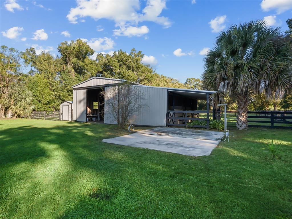3505 Northeast 97th Street Road Anthony, FL 32617 - Photo 29 of 38 a view of a backyard with table and chairs with a fire pit and a yard