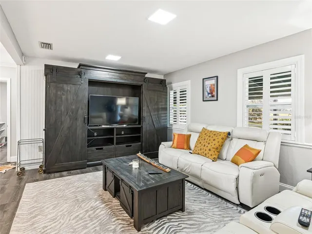 a living room with furniture and a dining table with kitchen view