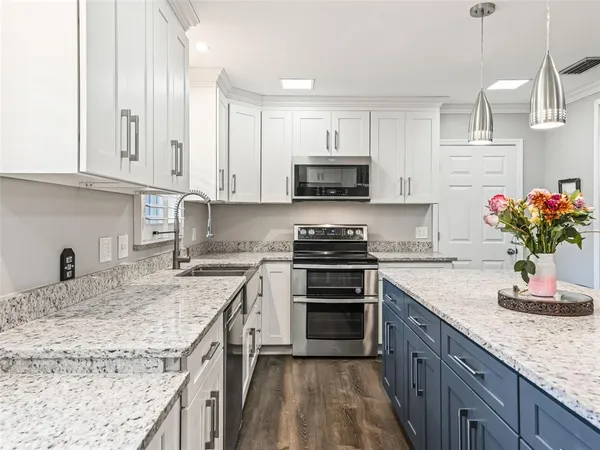a kitchen with granite countertop a sink and a stove