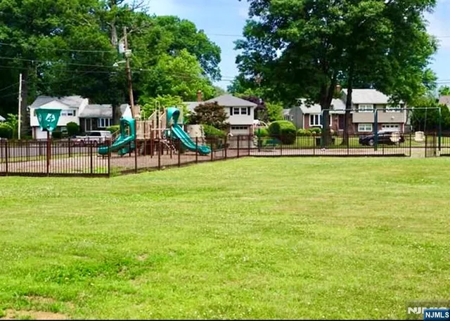 a view of a house with a big yard and large trees