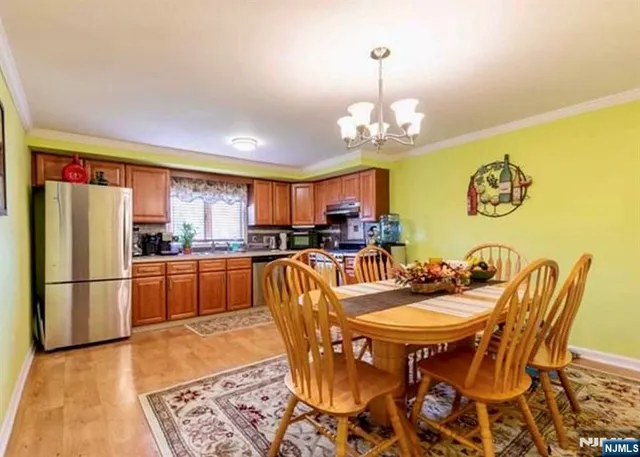a kitchen with stainless steel appliances granite countertop a dining table and chairs