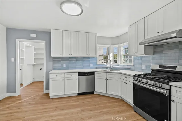 a kitchen with stainless steel appliances granite countertop a stove and a sink