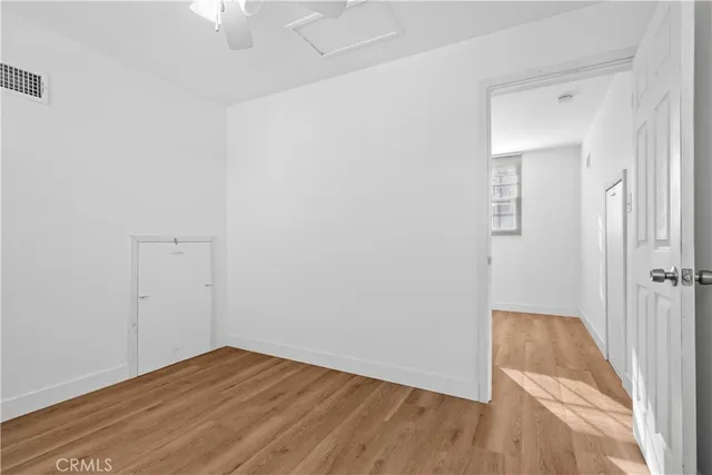 an empty room with wooden floor and closet
