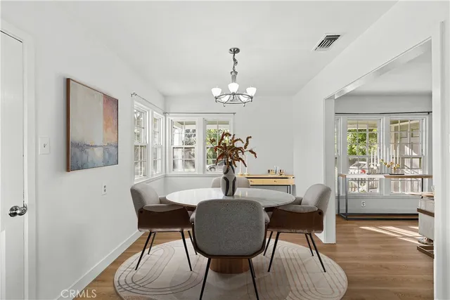 a dining room with furniture potted plants and wooden floor