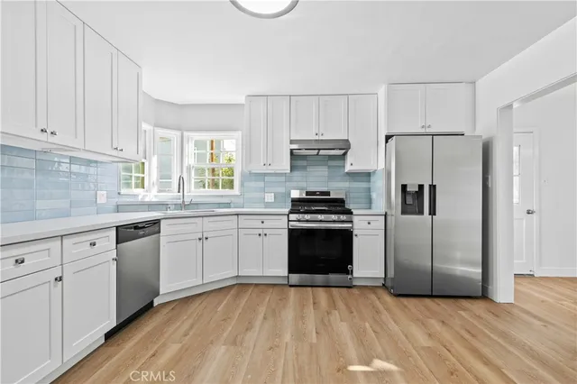 a kitchen with granite countertop a refrigerator stove and sink