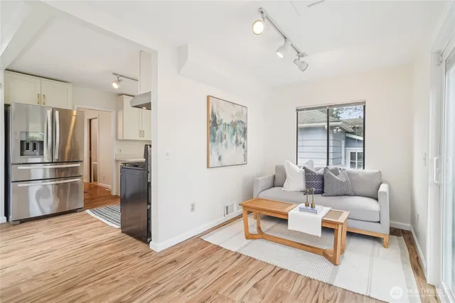 a living room with furniture and a refrigerator