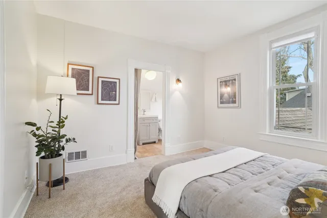 a bedroom with a bed and a potted plant