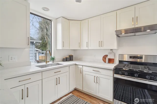 a kitchen with white cabinets and appliances