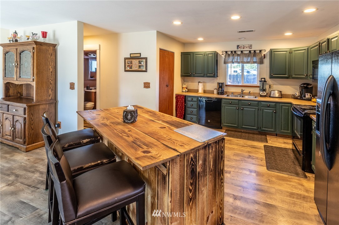 7122 Enterprise Road Ferndale, WA 98248 - Photo 13 of 33 a kitchen with stainless steel appliances kitchen island granite countertop a table chairs and a refrigerator