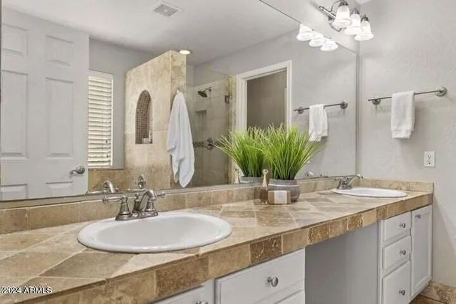 a bathroom with a double vanity sink and a mirror