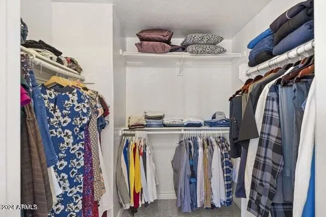 a view of walk in closet with clothes